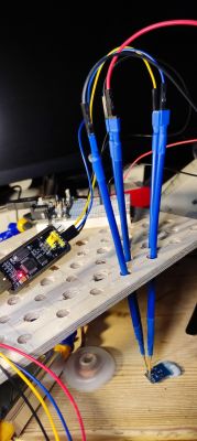 USB-TTL Adapter Connection to Test Board Connected wires with USB-TTL adapter and test board on a wooden surface.