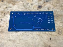 Blue PCB with etched traces and mounting holes.
