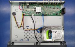 Wnętrze rejestratora BCS-B-XVR1602 z dyskiem twardym i widoczną płytą główną.