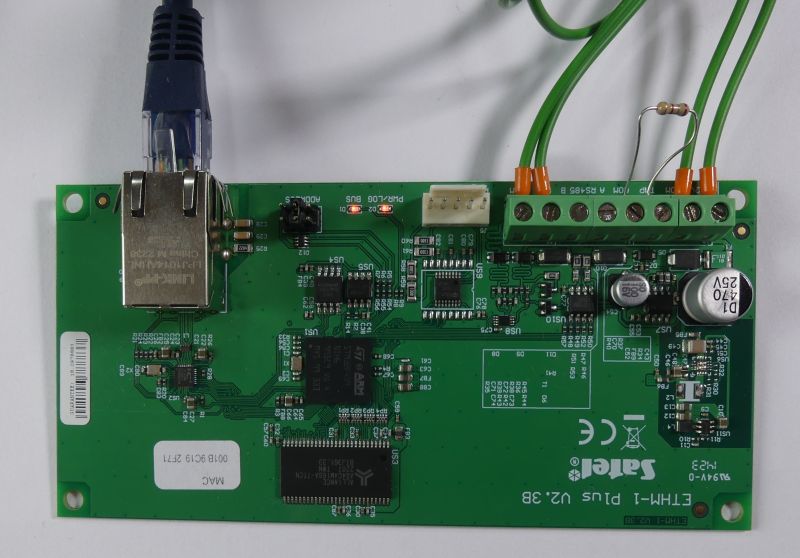Płytka PCB z podłączonym przewodem Ethernet i zielonymi kablami w terminalu śrubowym
