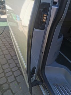 Widok na krawędź drzwi suwanymi VW Transporter T5 Multivan z widocznym mechanizmem połączeniowym.