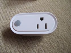MOES Smart Plug on Carpet MOES smart plug on a light carpet with a button on the left side.