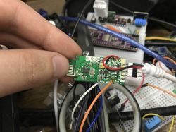 WiFi BL602 module held between fingers, connected to a breadboard with wires.