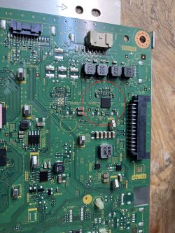 Zbliżenie na płytkę PCB z zaznaczonym uszkodzonym układem scalonym bez widocznego oznaczenia.