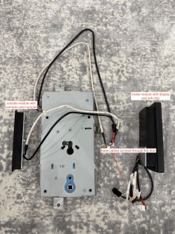 Electronic lock with cables and components on a gray background.
