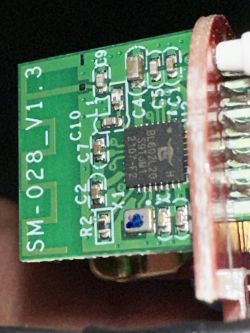 Close-up of a smart plug circuit board with markings and components.