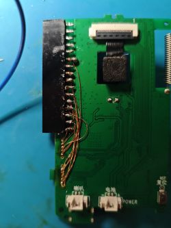 Close-up of a PCB with thin soldered wires and various connectors