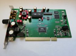 Green PCI card with a knob, audio jacks, and many capacitors on a white background