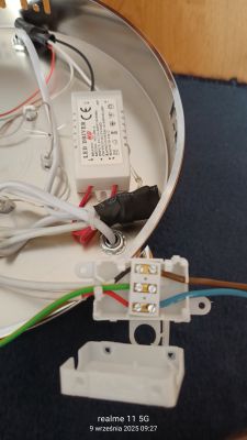 Zbliżenie na podłączenie przewodów żyrandola i kostkę elektryczną z sześcioma przewodami