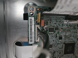 Zbliżenie na płytę elektroniki z taśmą i przewodami wewnątrz urządzenia