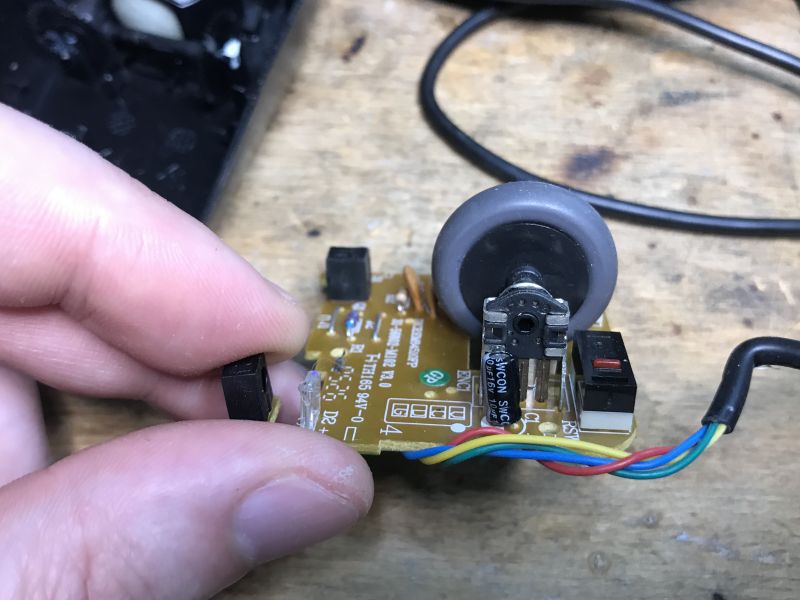 Interior of a Computer Mouse with Encoder Interior of an old computer mouse with a visible encoder and colored wires.