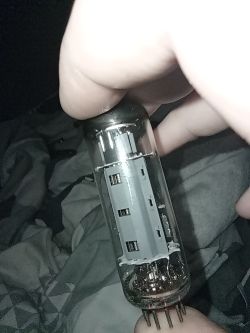 Lampa elektronowa trzymana w dłoni nad materiałem w odcieniach szarości