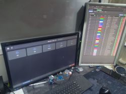 Two monitors showing electronic parts inventory and LED database interface