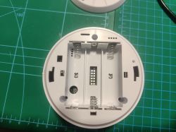 Image of the inside of a Tuya smoke detector with a circuit board marked v2.