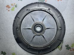 Metalowa tarcza z łożyskiem, leżąca na stole.