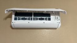 Open Indoor Unit of Della Optima Mini Split Air Conditioner The image shows the indoor unit of a white mini split air conditioner with its front cover open, revealing the filter and evaporator coil.