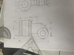 Rysunek techniczny części mechanicznej z wymiarami i przekrojem, otoczony ekierką i kątomierzem.