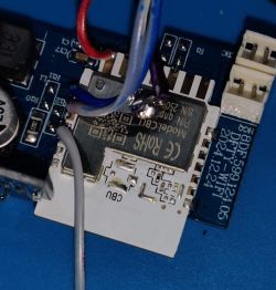 Close-up of WiFi module with soldered wires and visible PCB markings