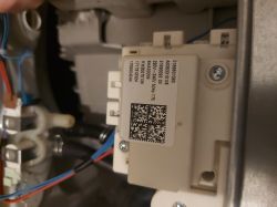 Widok wnętrza urządzenia z modułem elektronicznym i przewodami.