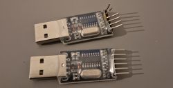 Two USB-UART converters with visible damage on one of them