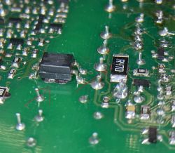 Zbliżenie na płytę drukowaną z różnymi komponentami elektronicznymi, w tym transoptorem PC817 i rezystorem R470.