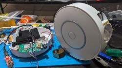 Open casing of an electronic device with visible components, cables, and motherboard.