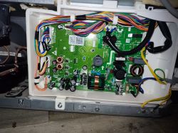 Wnętrze lodówki z odsłoniętą płytką elektroniczną i kolorowymi przewodami.