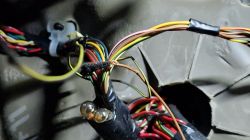 Zdjęcie zbliżenia na wiązkę przewodów w samochodzie, gdzie widać, że jeden z przewodów jest nieprofesjonalnie połączony z innym.