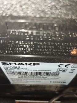 Zbliżenie na etykietę informacyjną telewizora Sharp LCD, model 40BF4E z widocznym numerem seryjnym i danymi technicznymi.