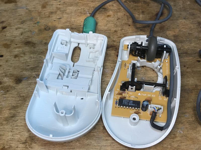 Disassembled Ball Mouse with Circuit Board Interior of a disassembled ball mouse showing the circuit board and mechanical components.