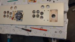 Construction of a Bartop Arcade Game Machine Front Panel Front panel of a bartop arcade game machine under construction, with holes for buttons and a joystick.
