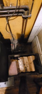 Widok na instalację hydrauliczną z drewnem przygotowanym do pieca.