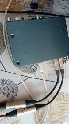 Interfejs audio z podłączonymi kablami XLR i USB na wzorzystym obrusie