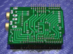 Green PCB with visible traces and electronic components, such as goldpins.
