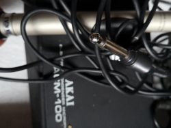 Zdjęcie mikrofonu pojemnościowego AKAI M-100 z widocznym wtykiem jack.