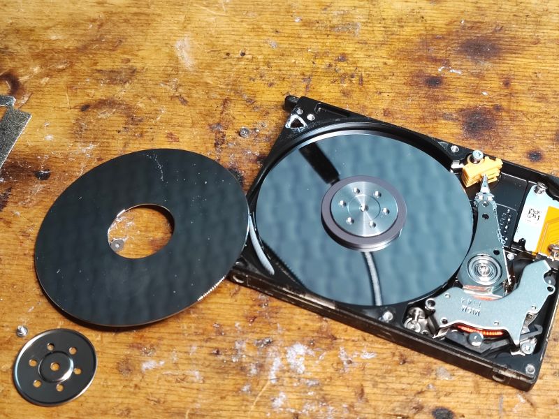 Inside of a Hard Drive with Removed Platter Inside of a hard drive with a removed platter on a wooden background