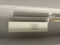White intercom mounted on a wall with a visible handset.