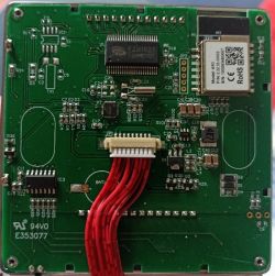 Green PCB close-up with IC chips, a QR-labeled module, and red wires connected to a white connector