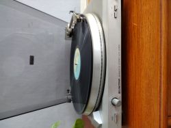 Gramofon Unitra z odtwarzaną płytą winylową.