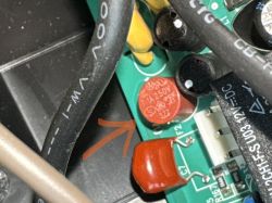 Zbliżenie na płytkę drukowaną UPS APC ES 550 z bezpiecznikiem topikowym 1A 250V oznaczonym strzałką.