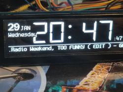 Electronic display showing time, date, and radio information