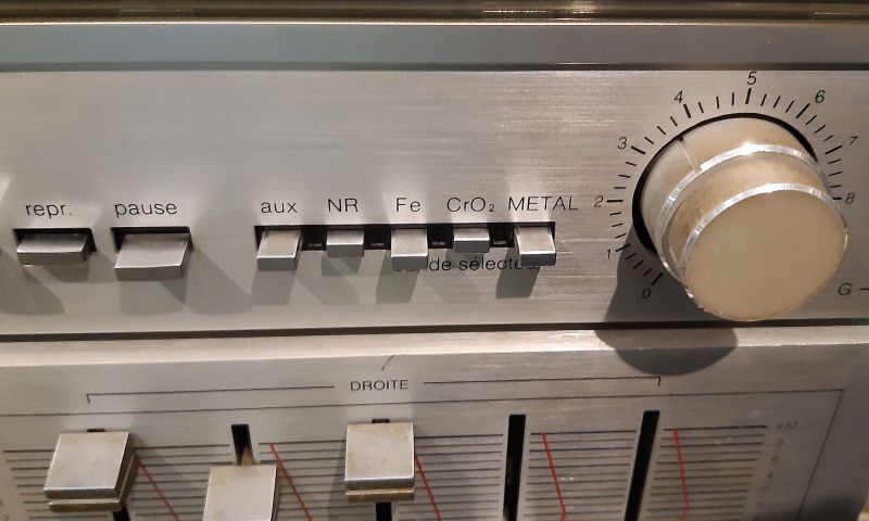Panel magnetofonu z metalowymi przyciskami i pokrętłem głośności ze skalą 0–8