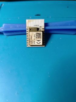 Electronic module on a blue background with a QR code and markings.