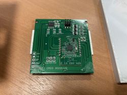 Circuit board with electronic components and a WiFi module on a wooden surface.