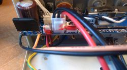 Wnętrze zasilacza z widocznymi przewodami i elementami elektronicznymi.