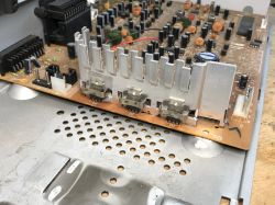 Płytka drukowana starego tunera satelitarnego z elementami elektronicznymi i radiatorami.