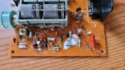 Płytka radiowa z komponentami elektronicznymi, w tym cewkami i kondensatorami.