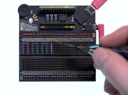 Płytka prototypowa Jumperless V5 z aktywnymi diodami LED RGB i sondą dotykową.