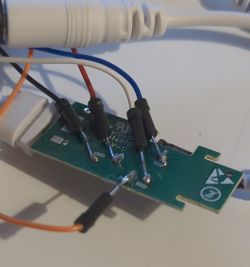 Close-up of a circuit board with wires connected for programming a Magic Home LED controller.