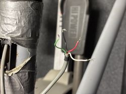 Odcinek przewodów z wystającymi końcówkami obok bieżni STAR TRAC Pro.